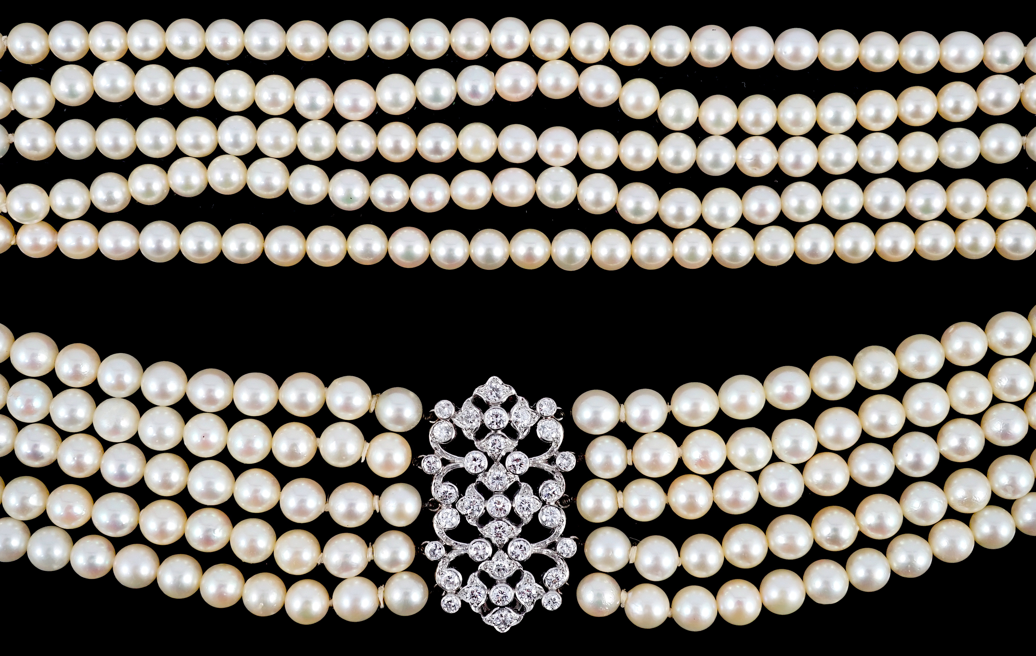 A mid 20th century quintuple strand cultured pearl choker necklace, with diamond cluster set white gold clasp and diamond cluster set white gold scrolling central motif, together with a matching bracelet
